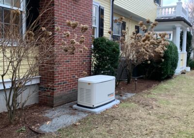 A small generator placed in front of a house, providing backup power during emergencies.