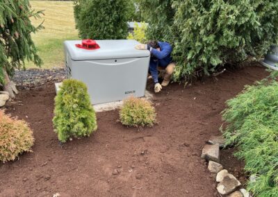 A man in a garden is working on a gas generator, ensuring its proper functioning.