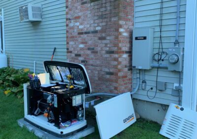 A man diligently working on a small generator in the yard