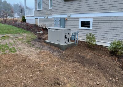 A generator placed beside a house in a yard.