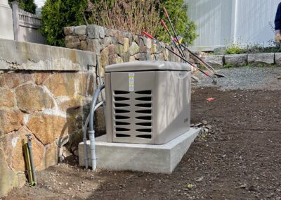 An individual walks past a generator in a yard, producing power and energy in an outdoor setting.